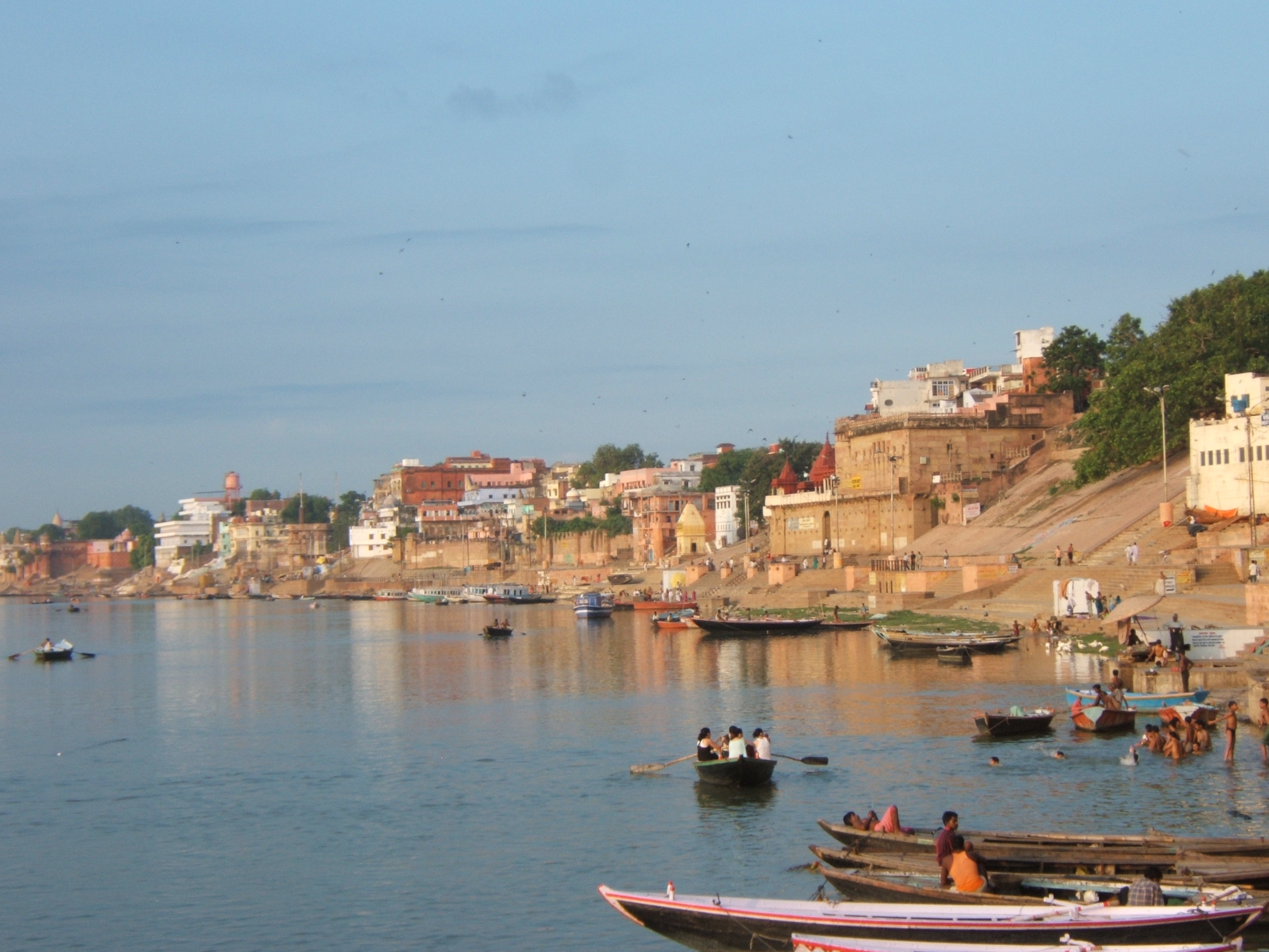 Boats and pilgrims along the ghats of the Ganges River in Varanasi at sunrise