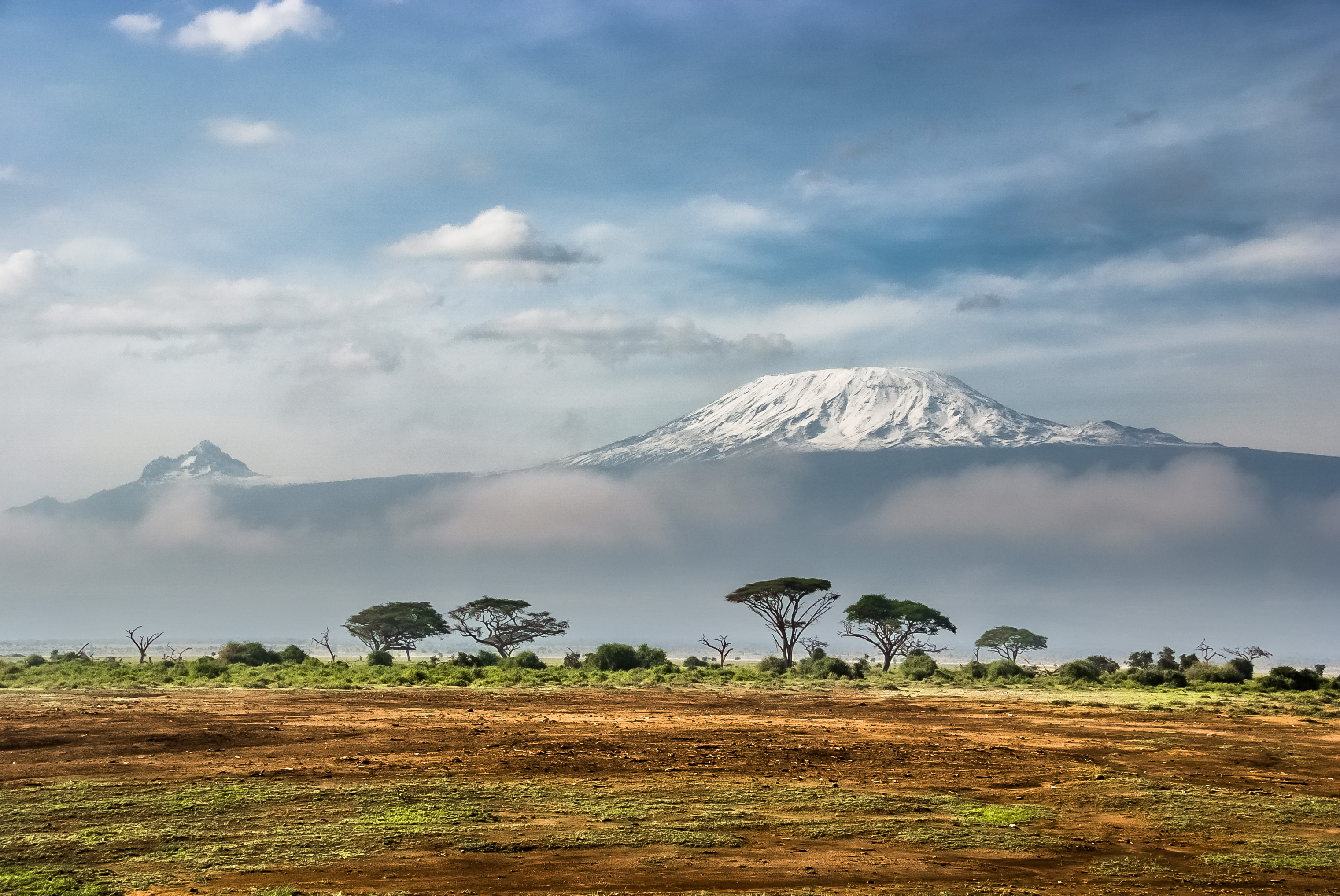 Explore Tanzania's 10 Mountains and Volcanoes 4 Snow-capped Mount Kilimanjaro seen from Amboseli, with Mawenzi peak alongside