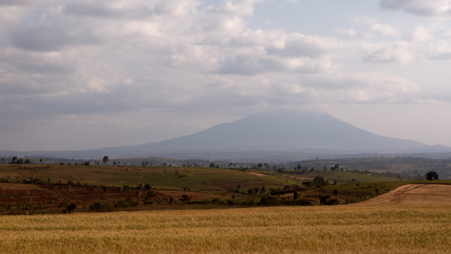 Explore Tanzania's 10 Mountains and Volcanoes 8 Mount Hanang volcanic silhouette over Tanzanian farmland