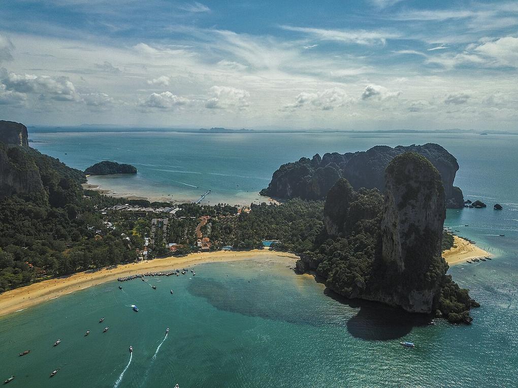 The salty breeze mixes with limestone dust at Phra Nang Beach, where longtail boats bob against white sand.