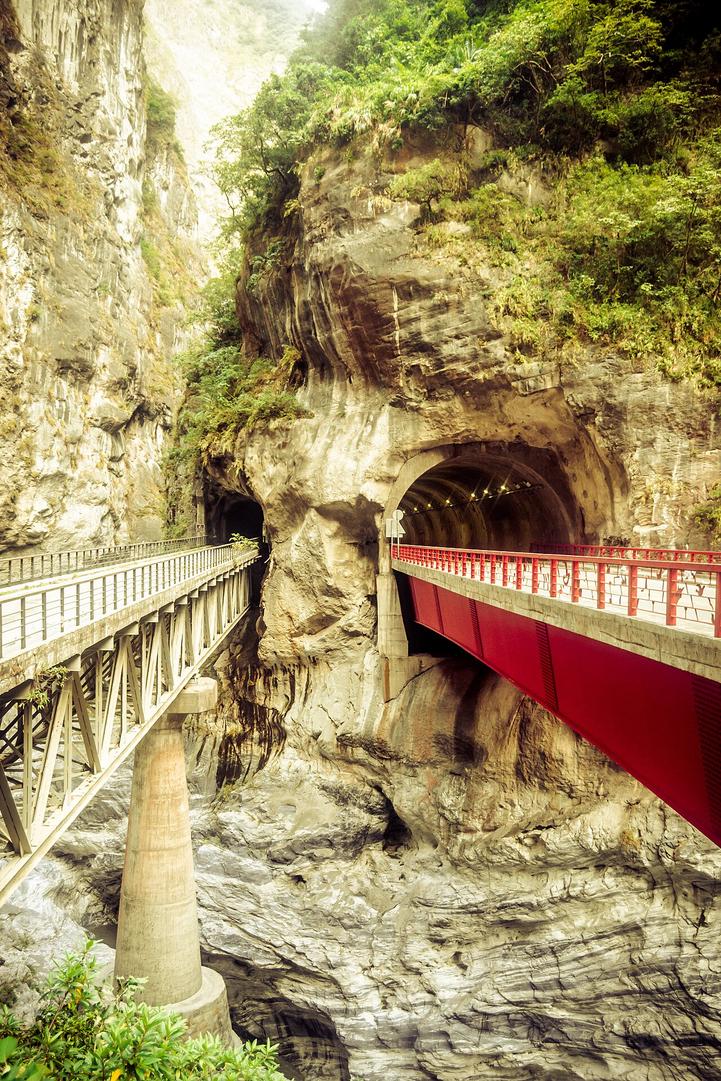 Hear the river roar beneath the Swallow Grotto cliff tunnels as sunlight filters through marble walls.